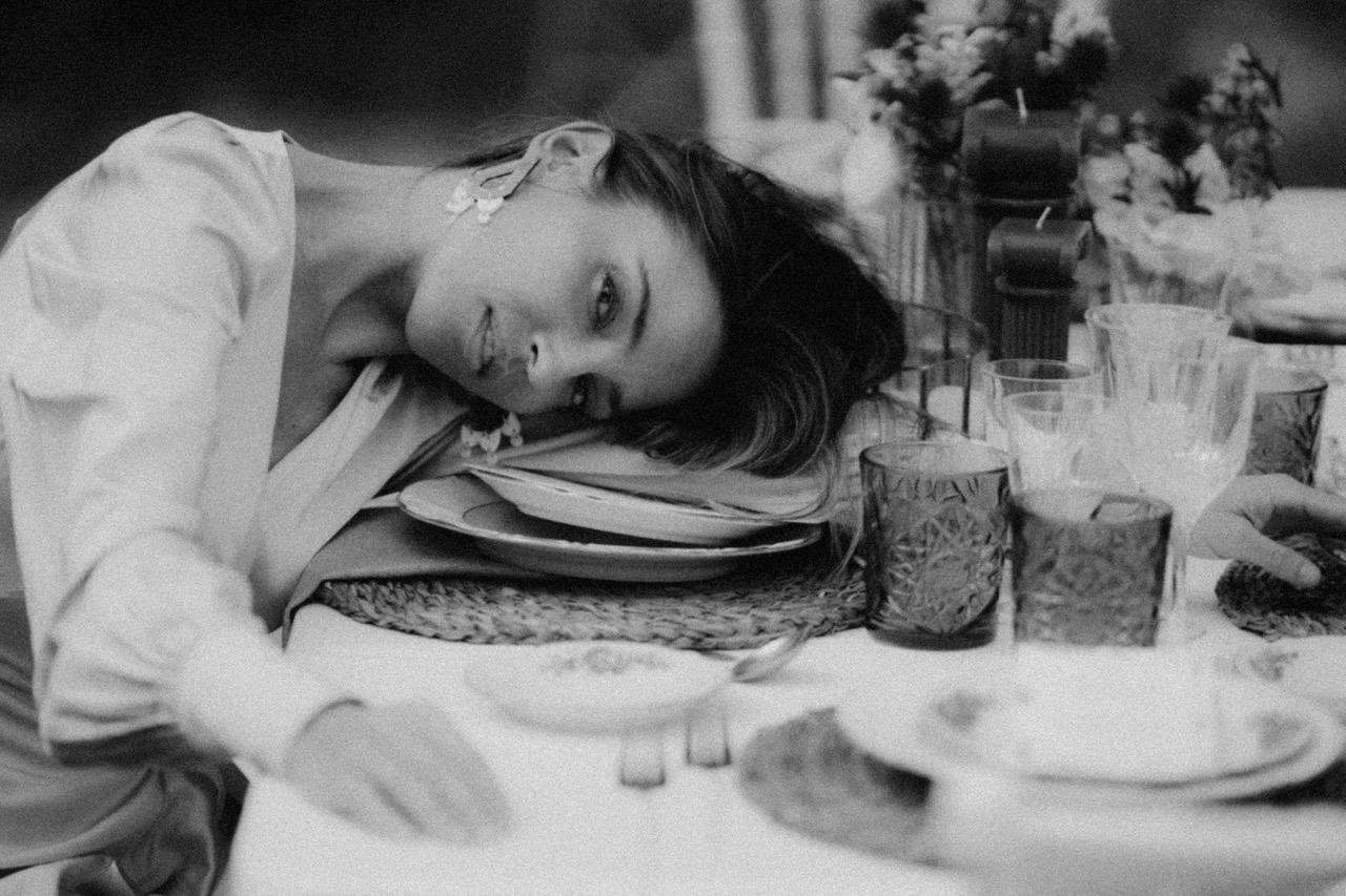 Una novia tumbada sobre una mesa y sonriendo