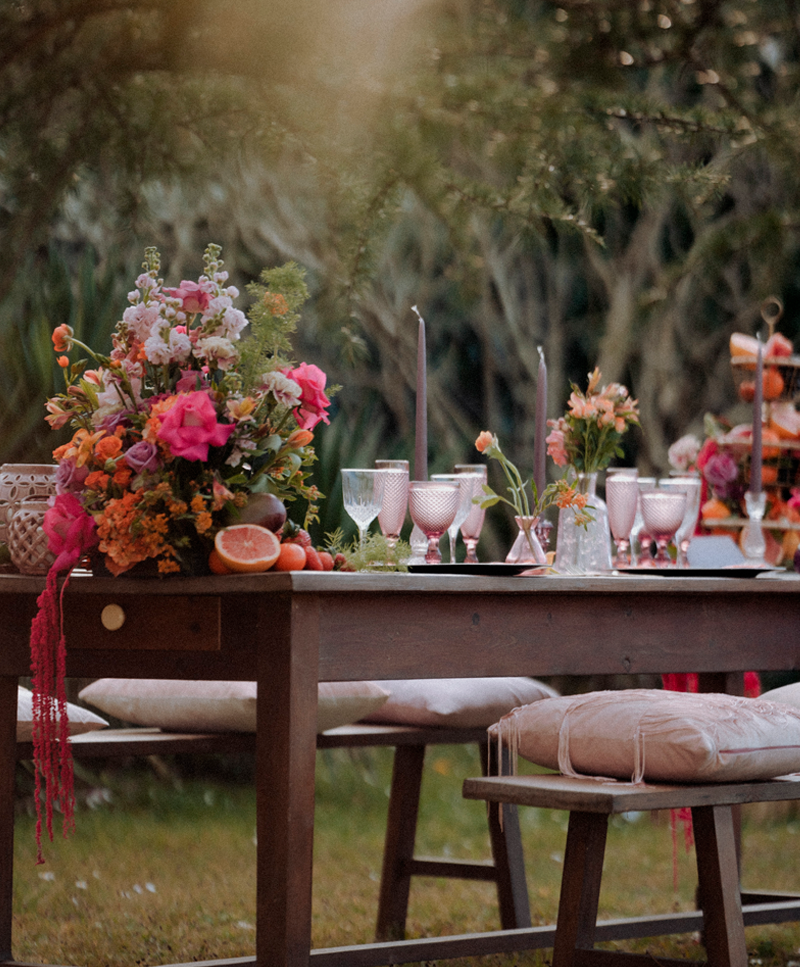 Se muestra una mesa muy bien decorada con flores y copas